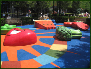 Playground with colorful flooring and plastic fruit and vegetable climbing figures.